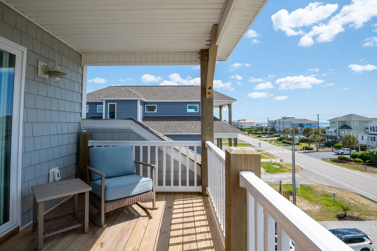 This view focuses on a serene balcony setup, complete with a blue chair and wooden railing, inviting relaxation while enjoying the expansive scenery. The image emphasizes the peaceful atmosphere and the opportunity for solitary moments or quiet conversations.